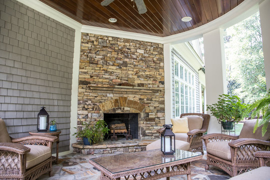 Back Stone Patio Porch Of Large Home With An Outdoor Fireplace