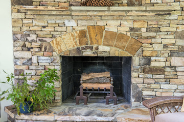 Back Stone Patio Porch of large Home with an outdoor fireplace