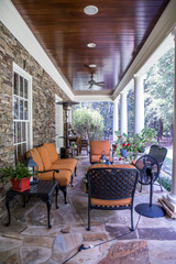 Outdoor Stone Patio Porch of large home estate with orange rust colorseating