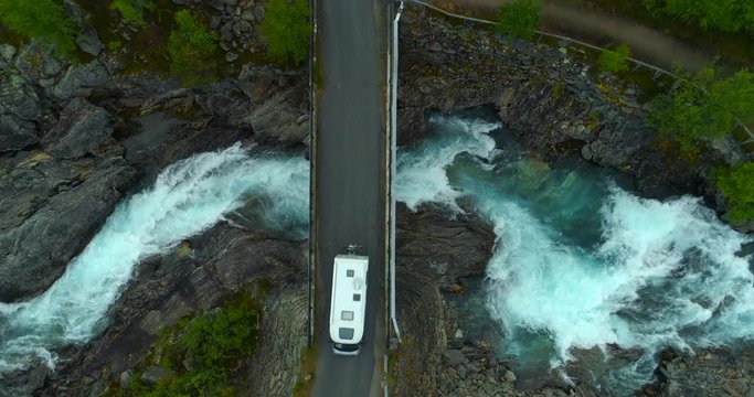 Aerial: Drone shot of camper van on bridge over flowing river - Oppland, Sweden