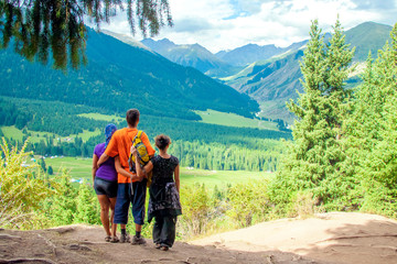 Fototapeta na wymiar Three tourists hugging enjoying mountain views.