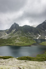 Fototapeta na wymiar Misty, moody, dramatic weather above beautiful Twin glacial lake on Rila mountain in Bulgaria