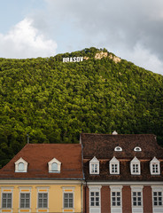Fototapeta na wymiar Brasov sign on the hill and city architecture