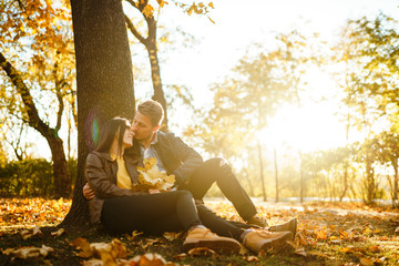 Lovely beautiful couple enjoying each other.  Beautiful autumn day. Lifestyle, happy couple of two play on a sunny day in the park. The concept of youth, love and lifestyle.