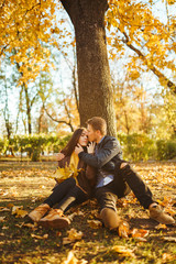 Lovely beautiful couple enjoying each other.  Beautiful autumn day. Lifestyle, happy couple of two play on a sunny day in the park. The concept of youth, love and lifestyle.