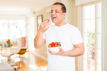 Middle age man eating strawberry at home