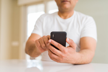 Close up of middle age man hands using smartphone at home
