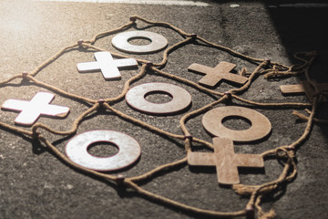 Game of tic tac toe, large, made of wood and ropes, on the cement floor. Game and fun concept for adults and children.