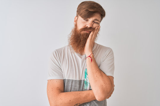 Young redhead irish man wearing t-shirt standing over isolated white background thinking looking tired and bored with depression problems with crossed arms.