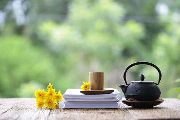 Yellow Chrysanthemum flowers with wooden cup and vintage old teapot on wooden table
