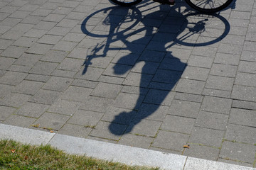 Schattenwurf einer Radfahrerin - fährt freihändig