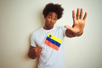 Afro american man holding Venezuela Venezuelan flag standing over isolated white background with...