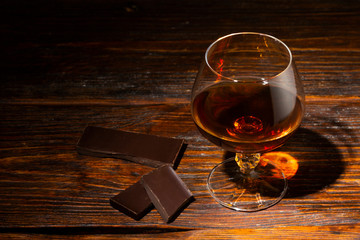 glass with cognac close-up on an old wooden background