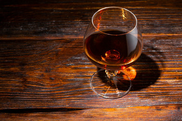glass with cognac close-up on an old wooden background