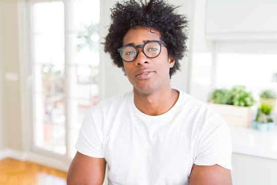 African American man wearing glasses Relaxed with serious expression on face. Simple and natural with crossed arms