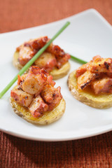 Potato starters with octopus, presentation of catering for celebration. Served on colored tablecloth.