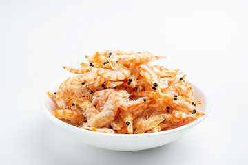 A plate of dried red shrimps on a white background