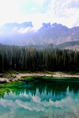Lake Carezza, the small mountain lake is famous for the dark green color, and the beautiful panorama of mountains in the background. Legend of King Laurin and his Rosegarden. South Tyrol, Italy. I