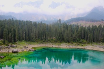 Fototapeta premium Lake Carezza, the small mountain lake is famous for the dark green color, and the beautiful panorama of mountains in the background. Legend of King Laurin and his Rosegarden. South Tyrol, Italy. I