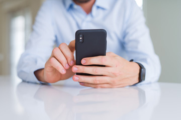 Close up of man hands using smartphone and smiling