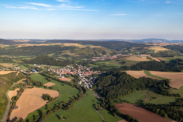 Fototapeta na wymiar Aerial view at a landscape in Germany, Rhineland Palatinate near Bad Sobernheim with the river Nahe, the village Staudernheim, meadow, farmland, forest, hills, mountains