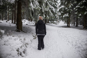 woman in the forest during falling snow, winter