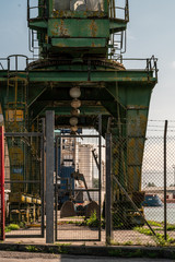 Through a gate, under the crane.
