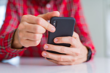 Close up of man hands using smartphone and smiling