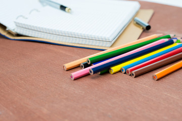 Blank paper and colorful pencils on old wooden table. Flat lay, top view.