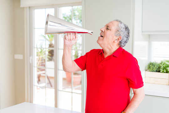Senior man shouthing excited through vintage metal megaphone