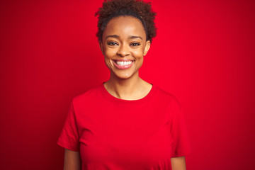 Young beautiful african american woman with afro hair over isolated red background with a happy and cool smile on face. Lucky person.