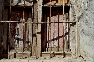 Old wooden window with rusty iron fence