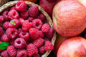 fresh raspberries and apples in a basket