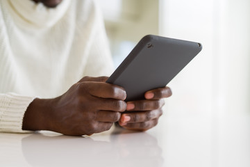 Close up of african business man using touchpad tablet, working sitting on a desk