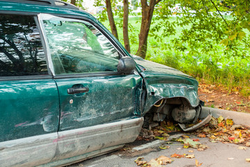 The car after the accident. The car's front wheel broke. A wrecked car is parked.