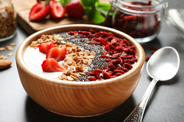 Smoothie bowl with goji berries and spoon on grey table © New Africa