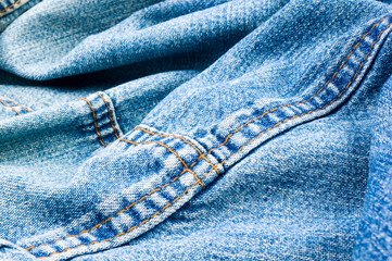 clothing items blue stonewashed faded jeans cotton fabric texture with seams, clasps, buttons and...