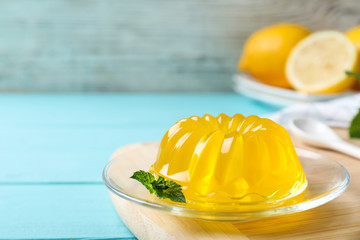 Delicious yellow jelly with mint on light blue wooden table - obrazy, fototapety, plakaty