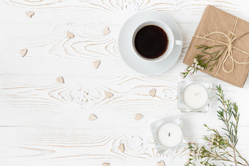 Top view of coffee, gifts, hearts, candles, flowers on white wooden table. Background with free space for text. Flat lay