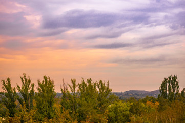 Obraz premium Autumn urban landscape on a Sunny day - yellow and colorful autumn trees, the sky with clouds with autumn haze