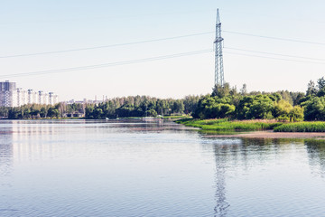 Obraz premium High voltage electric poles in the city of Minsk near Drozdovsky reservoir, Belarus. The high voltage pole, the blue summer sky, toned