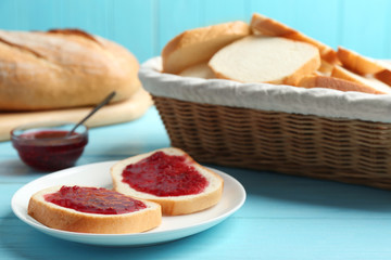 Tasty fresh bread with jam on light blue wooden table