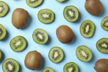 Top view of fresh whole and cut kiwis on light blue background