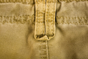 clothing items stonewashed cotton fabric texture with seams, clasps, buttons and rivets, macro