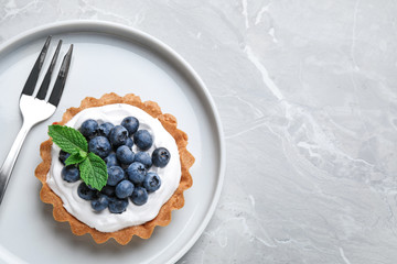 Tart with blueberries served on marble table, top view with space for text. Delicious pastries