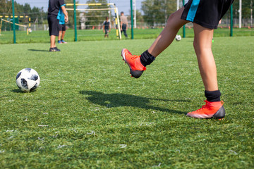 Soccer player in training. The feet of a football player. Ball game on the soccer field. Sports activities.
