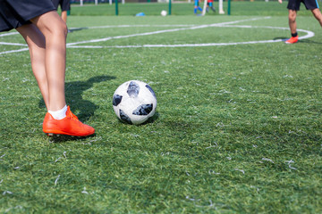 Soccer player on the soccer field plays the ball. Doing sports. Children play ball in a football team.