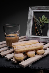 Ladyfinger biscuits for a Classic tiramisu dessert and a glass cup of coffee for dipping
