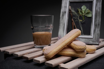 Ladyfinger biscuits for a Classic tiramisu dessert and a glass cup of coffee for dipping