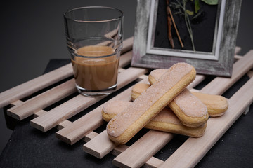 Ladyfinger biscuits for a Classic tiramisu dessert and a glass cup of coffee for dipping